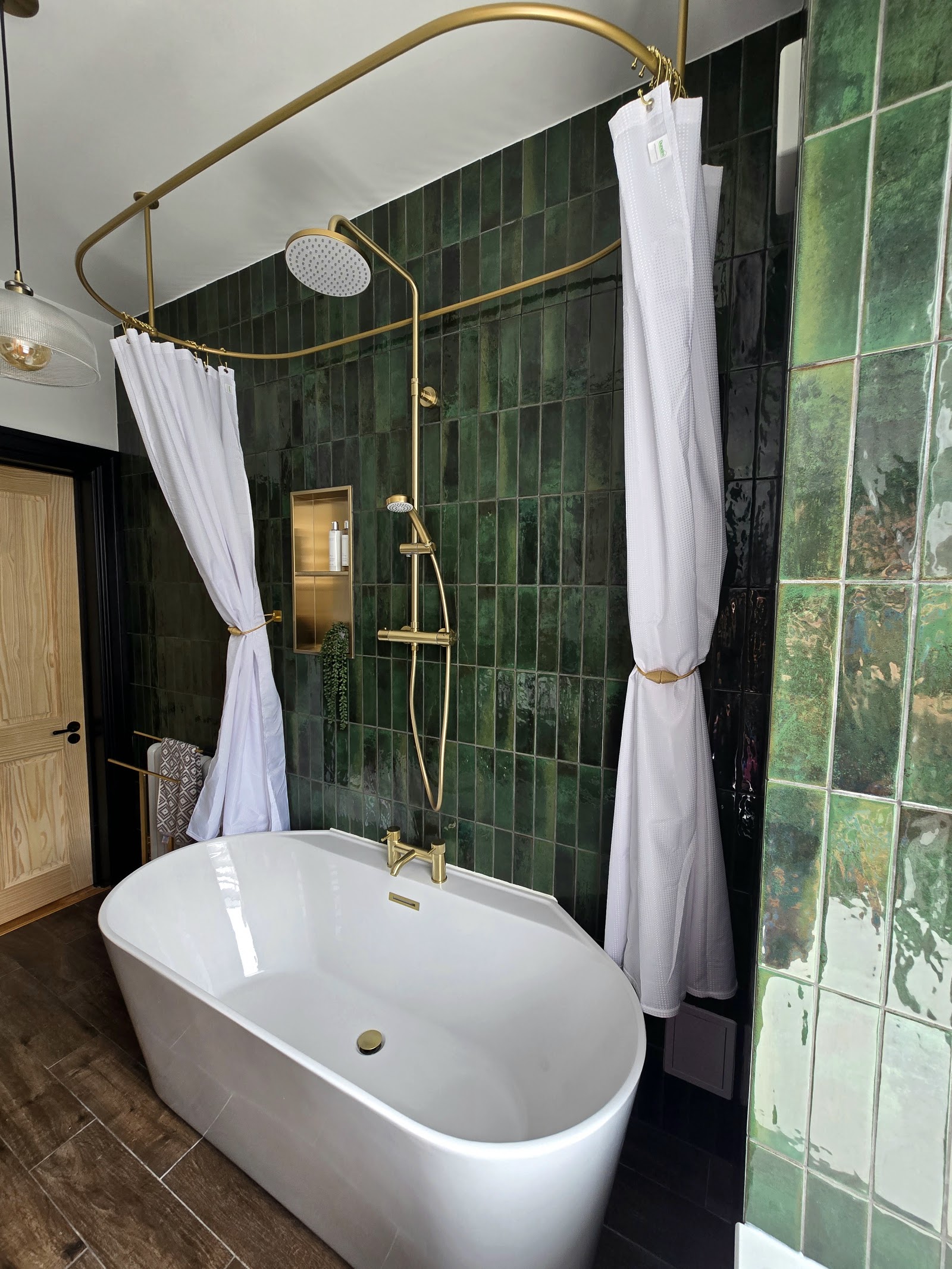 Green tiled bathroom with freestanding bath and brass shower rail, Plymouth